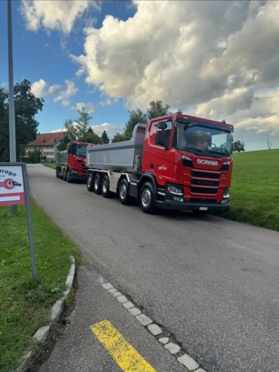 Zwei rote Kipper auf einer Strasse